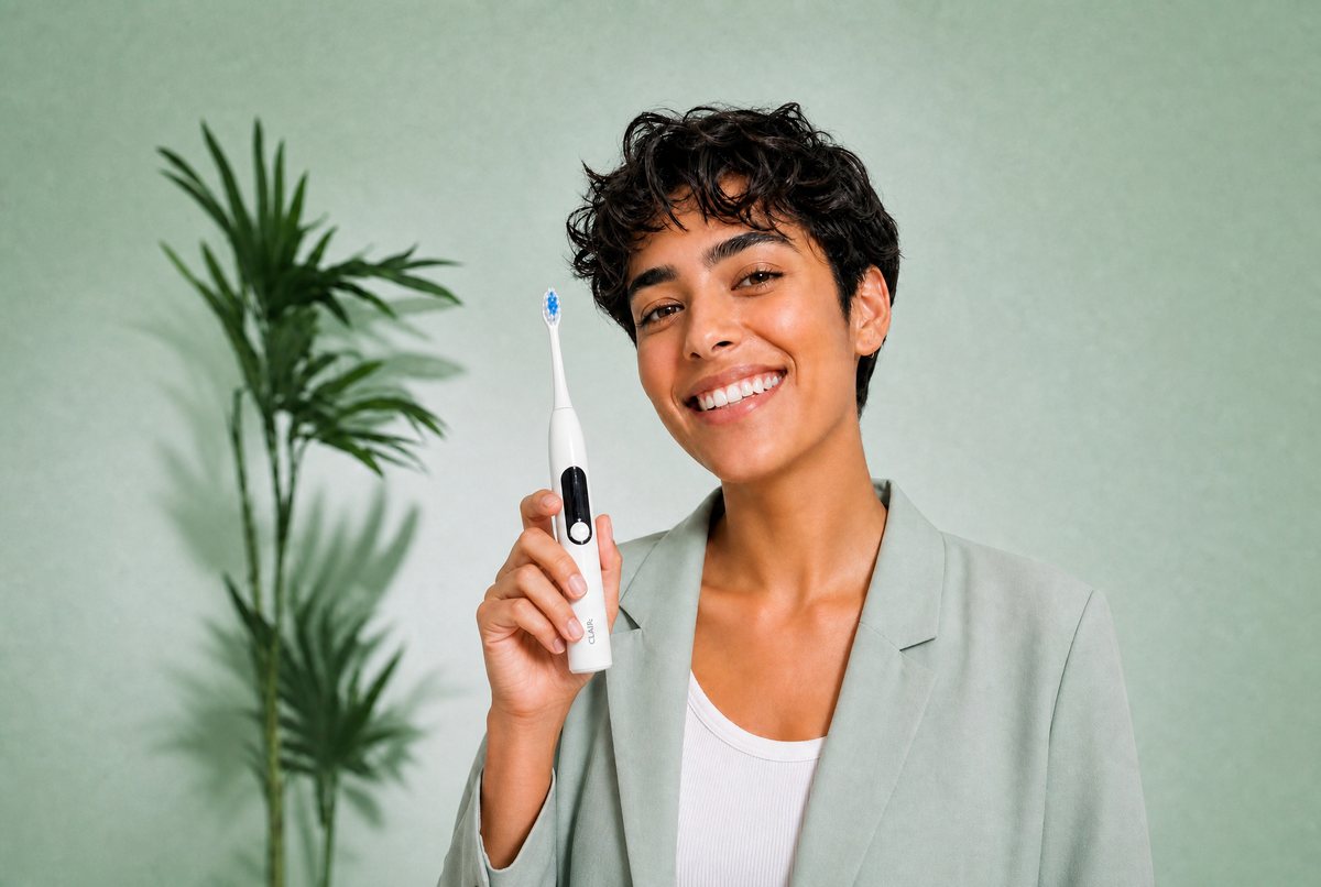 A woman holding a Clair SoniClair sonic toothbrush